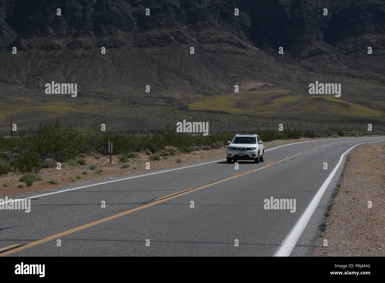 Bianco auto la guida su una strada nel deserto della California Foto Stock