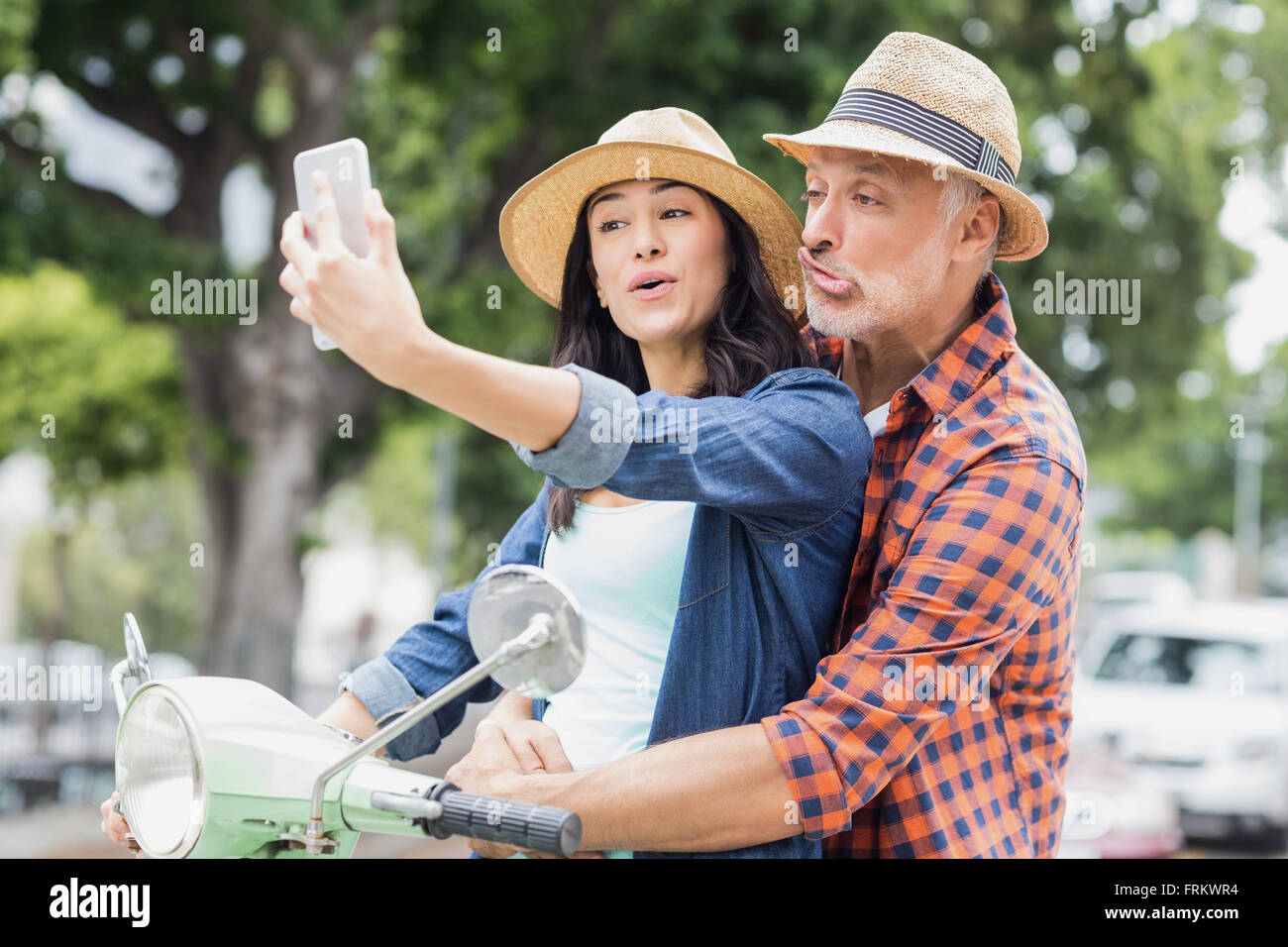 Uomo che fa la faccia per selfie con donna Foto Stock