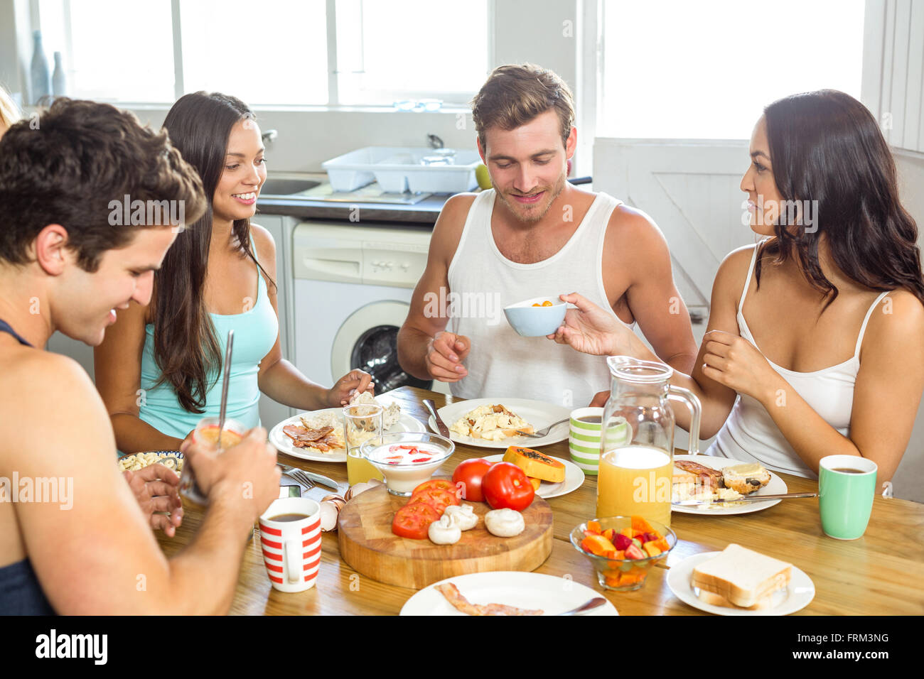 Coppia giovane avente la colazione con gli amici a casa Foto Stock