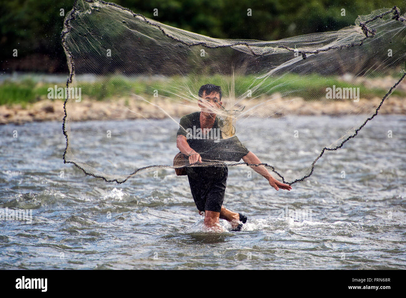 Asia. Il sud-est asiatico. Laos. Provincia di Vang Vieng. Villaggio Phatang. Pescatore di gettare la sua rete in un Nam Song river. Foto Stock