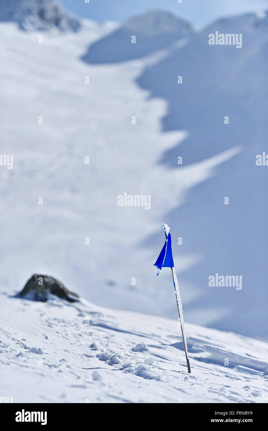 Bandiera Blu soffiata dal vento su una montagna in inverno Foto Stock