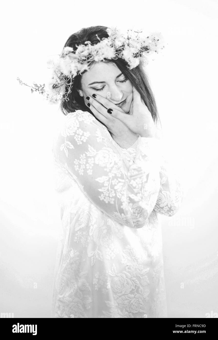 Bellissimo sogno giovane donna in un romantico abito bianco e fiori Foto Stock
