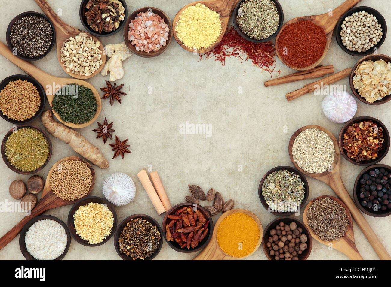 Erbe e spezie selezione formando un confine astratto sulla canapa naturale sfondo della carta. Foto Stock