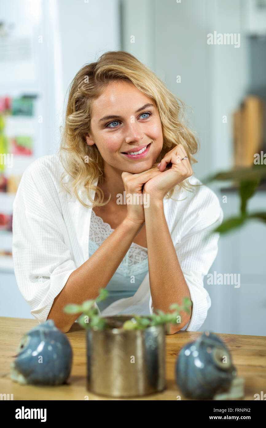 Felice giovane donna seduta a casa Foto Stock