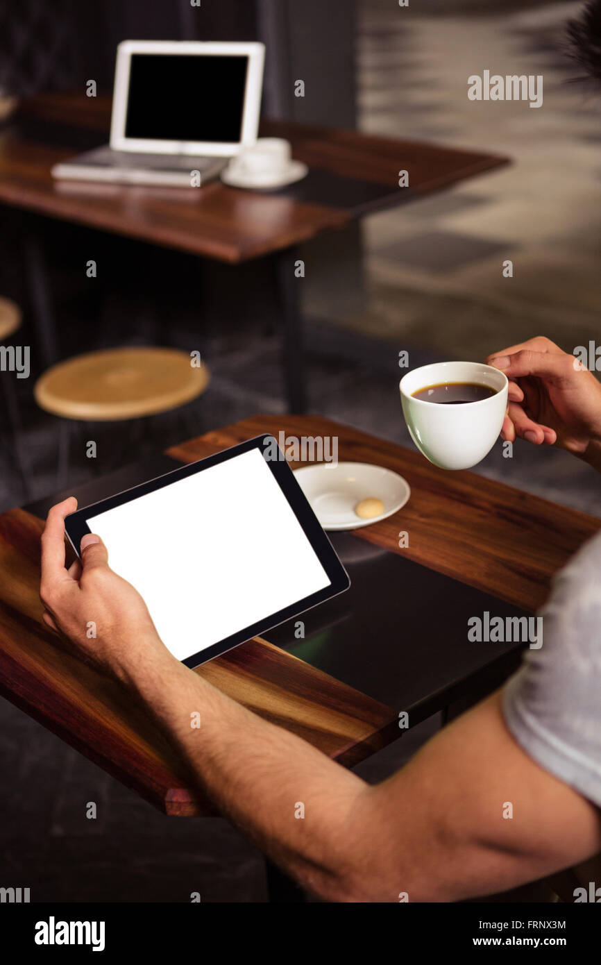 Hipster uomo utilizzando tablet mentre si beve il caffè Foto Stock