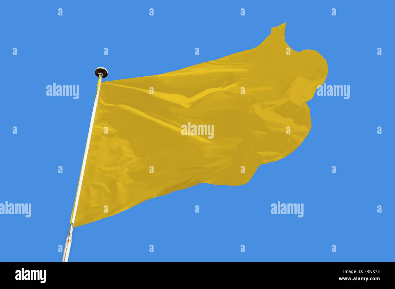 Bandiera gialla battenti in una brezza tesa contro un cielo blu chiaro. Foto Stock