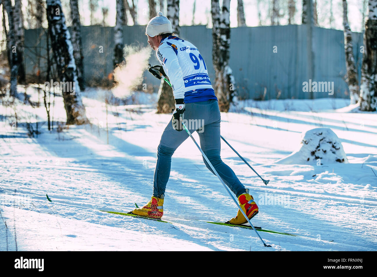 Atleta maschio sciatore durante la gara di foresta in stile classico. Il vapore durante la respirazione durante il campionato di Chelyabinsk in cross-country Foto Stock