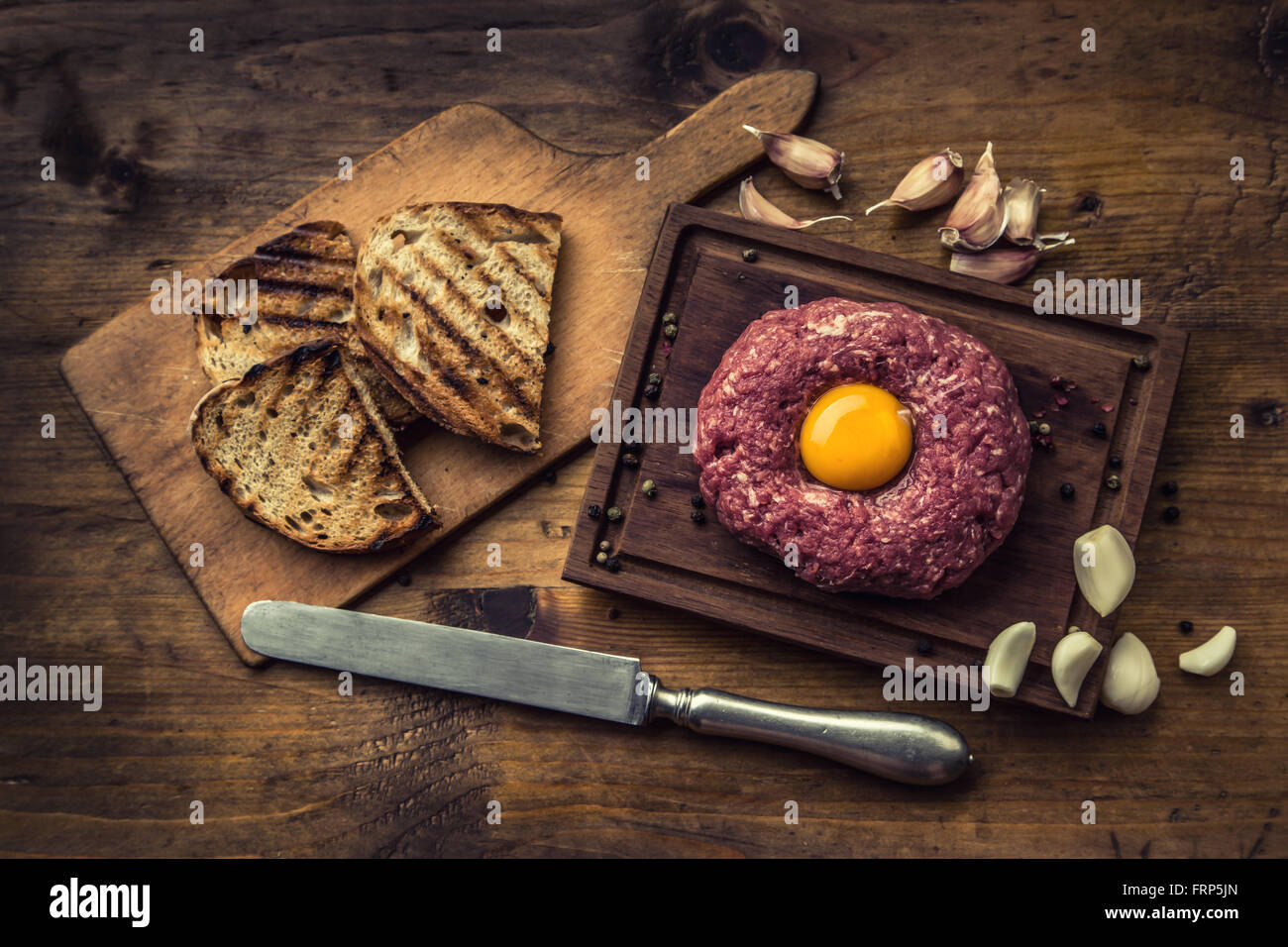 Carne di manzo crudo .gustosa tartare di manzo. Classic tartare di manzo sul tagliere in legno. Ingredienti: Materie di carni bovine sale pepe uovo Aglio Peperoncino Foto Stock