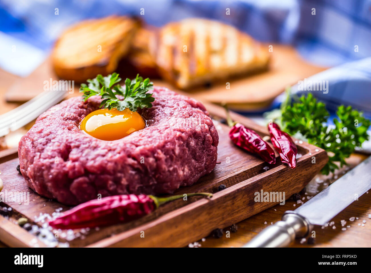 Carne di manzo crudo .gustosa tartare di manzo. Classic tartare di manzo sul tagliere in legno. Ingredienti: Materie di carni bovine sale pepe uovo Aglio Peperoncino Foto Stock