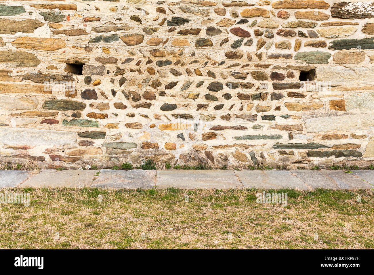 Sullo sfondo di un antico muro costruito con pietre Foto Stock