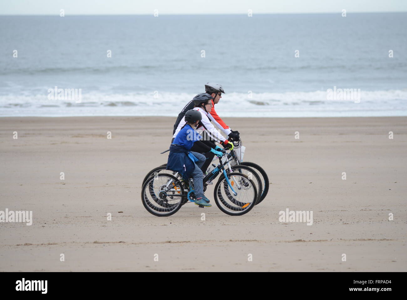 Una famiglia escursioni in bicicletta sulla spiaggia di Hunmanby, North Yorkshire, Regno Unito. Foto Stock