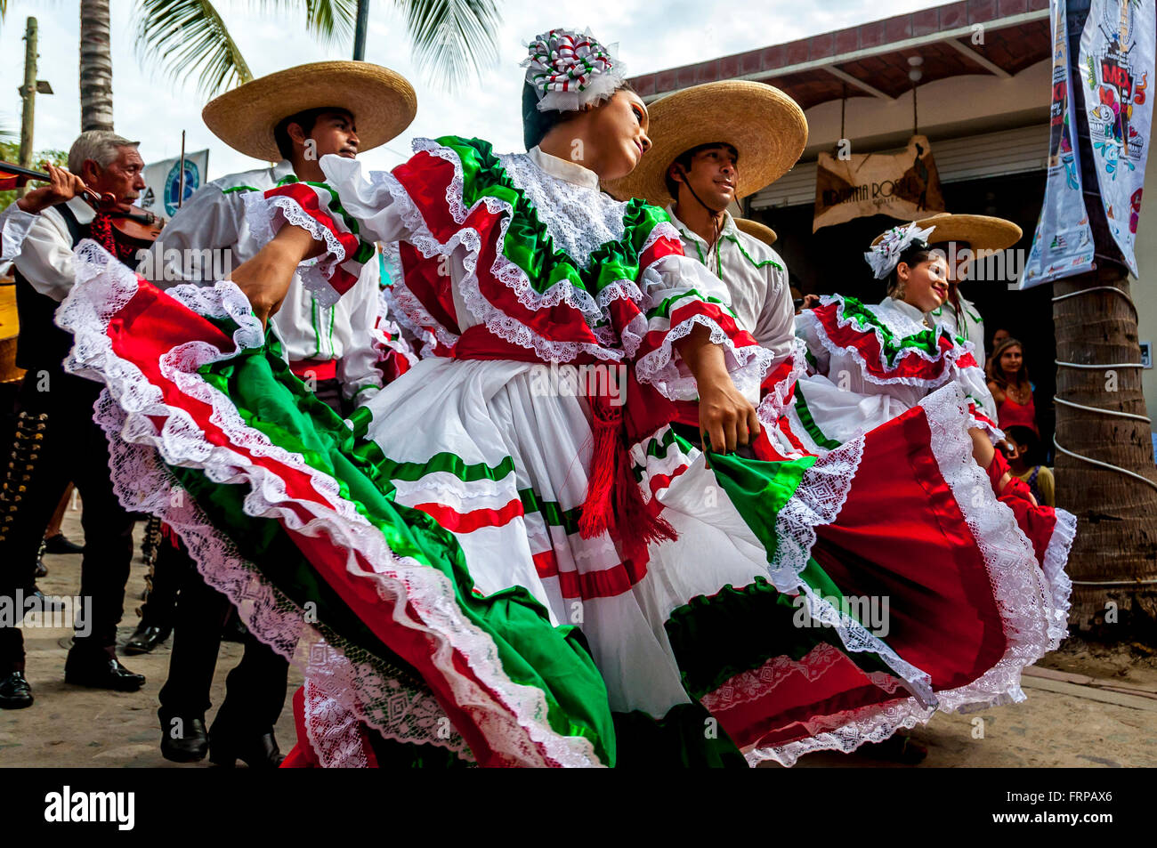 Sayulita, Nayarit: messicana ballerini indossare i colori luminosi del Messico della bandiera (rosso, bianco, verde) dancing in parata con mariachi. Foto Stock