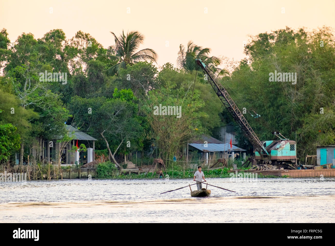 Un uomo pagaie attraverso il Can Tho River, Vietnam Foto Stock