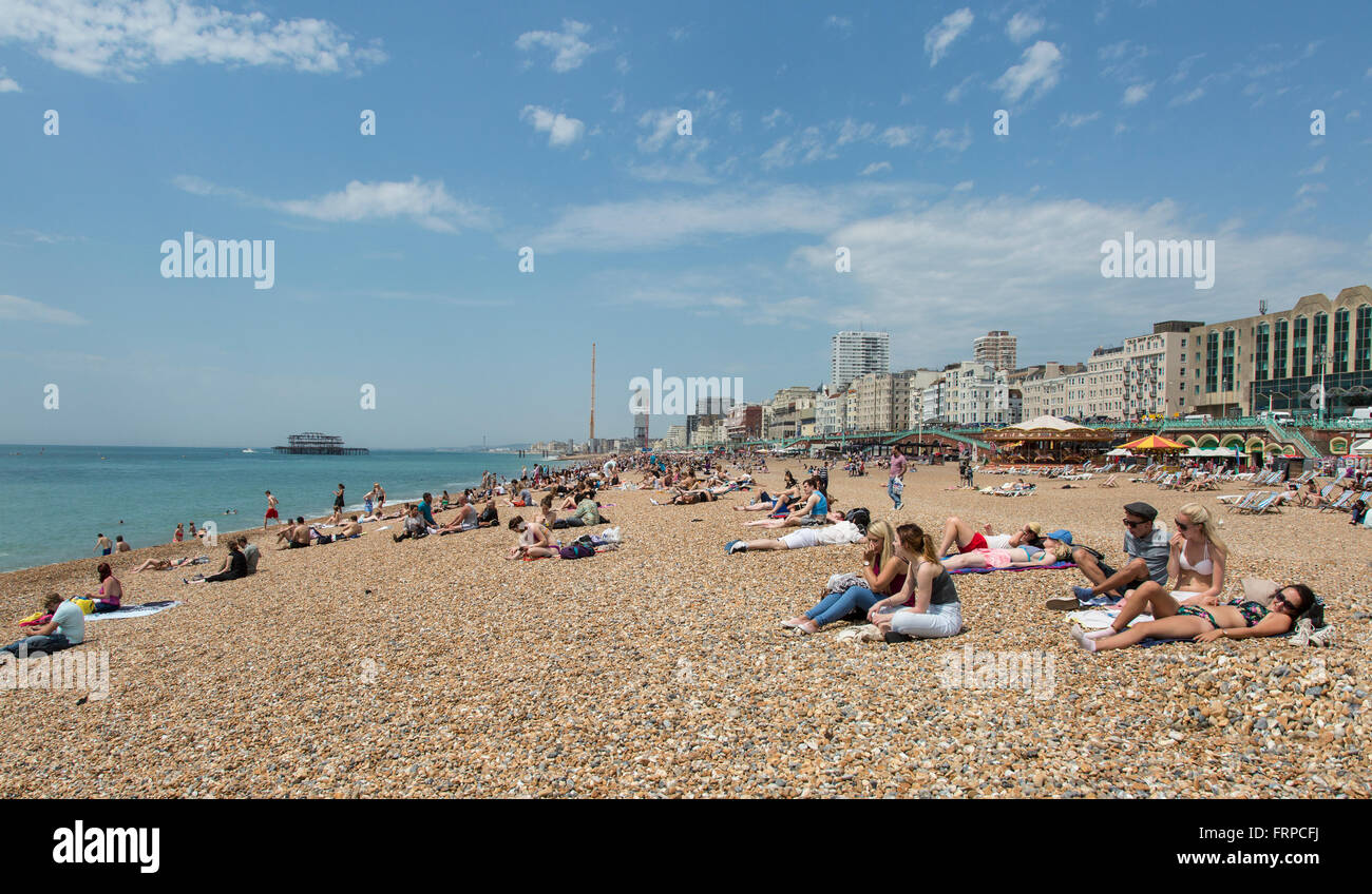 La gente a prendere il sole sulla spiaggia di Brighton e Hove, Regno Unito Foto Stock