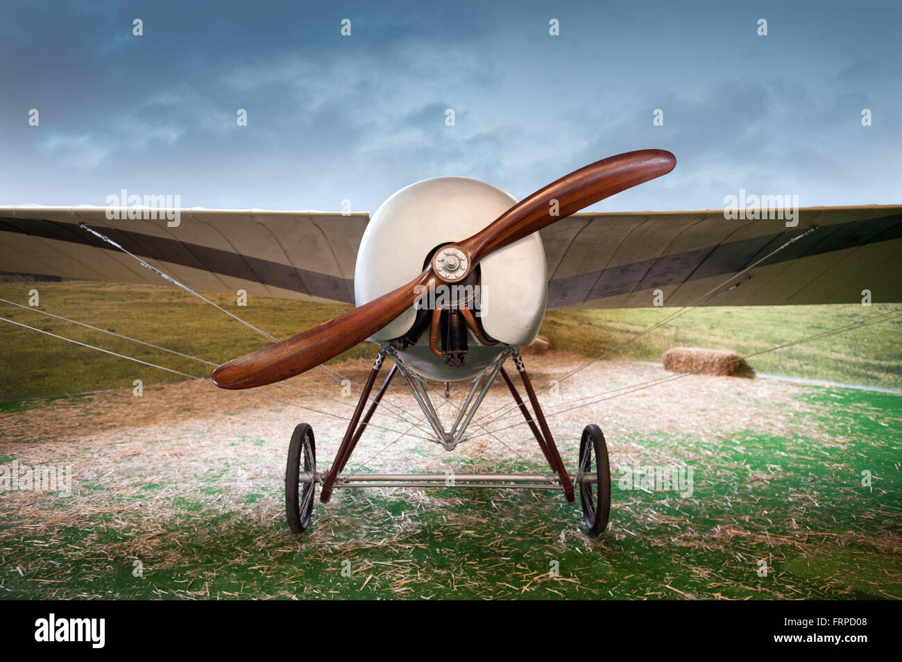 Vecchio vintage monoplan aereo con un propulsore di legno parcheggiato in un campo in un paesaggio, vista frontale Foto Stock