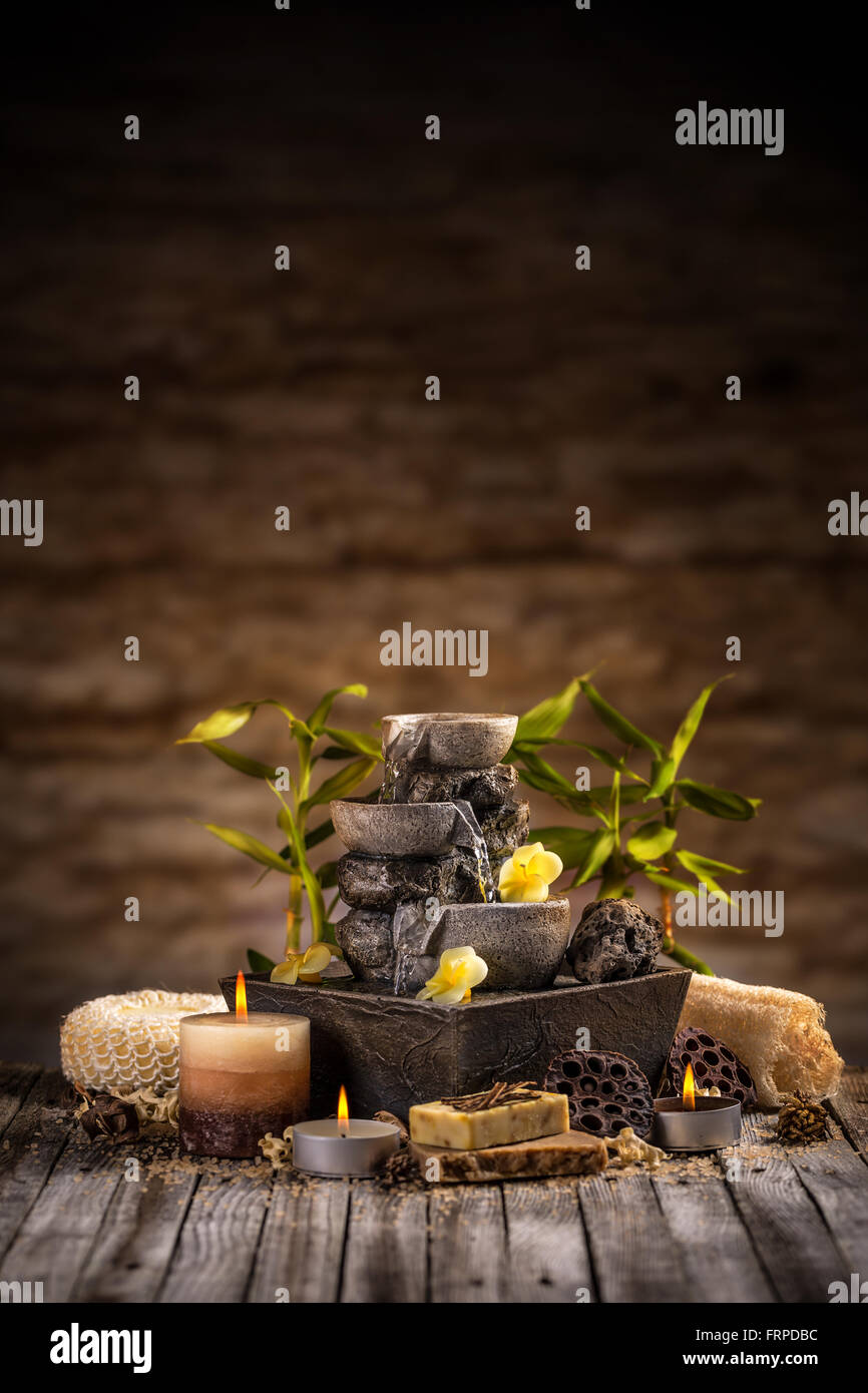 Spa e il concetto di benessere con fontana di acqua pietre e candele Foto Stock