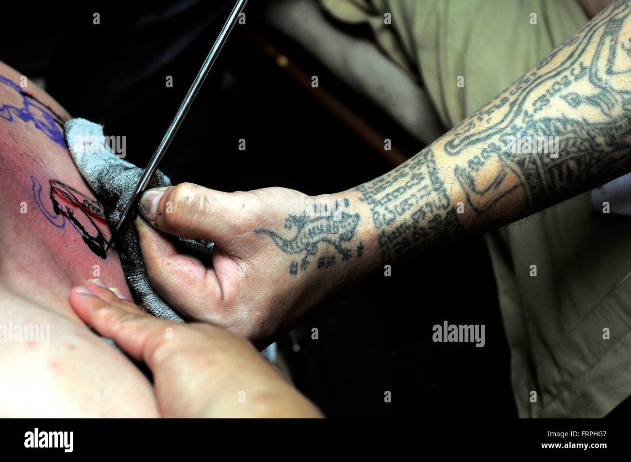 Tiger 'sak yant' (yan) tattoo in corso. Bangkok, Tailandia. Credito: Kraig Lieb Foto Stock