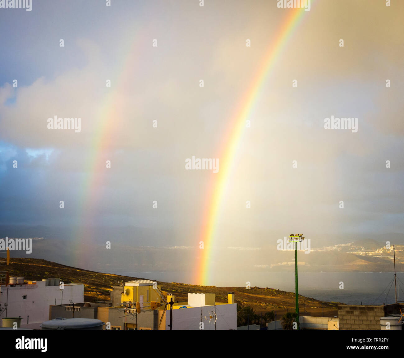 A Las Palmas di Gran Canaria Isole Canarie Spagna, 24 marzo 2016. Meteo: un doppio arcobaleno su Las Palmas, il captital di Gran Canaria a sunrise come una breve doccia passa sopra la città su un glorioso giovedì nelle isole Canarie. Regno Unito premere viene segnalato che il Primo Ministro David Cameron e la famiglia sono in volo per le isole Canarie (Lanzarote) il 24 marzo per le loro vacanze di Pasqua. Il cancelliere della Germania, Angela Merkel, viene riportato anche per volare in una delle altre isole Canarie (La Gomera) per la sua vacanza di Pasqua. Credito: Alan Dawson News/Alamy Live News Foto Stock