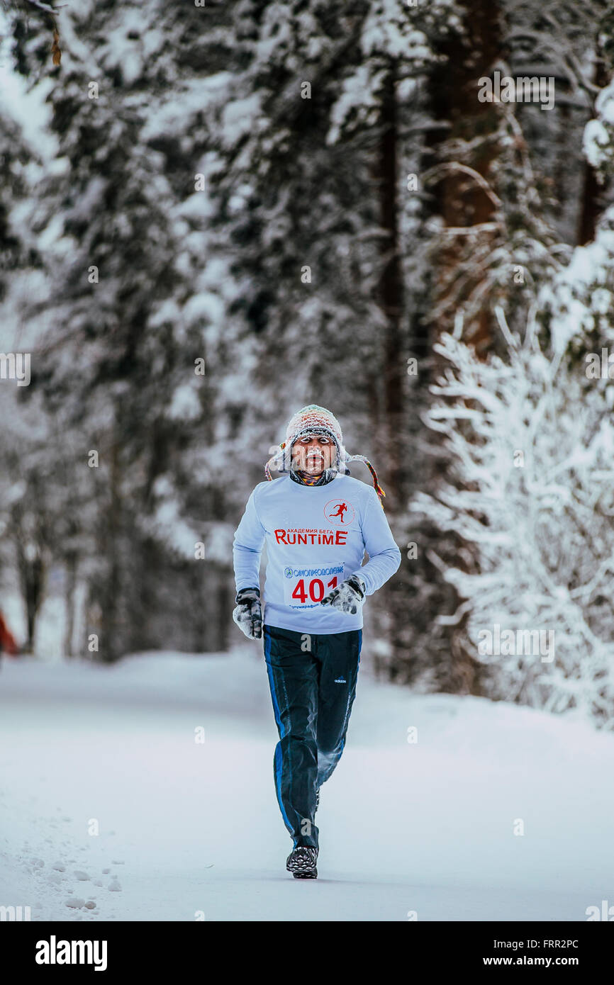 Piano generale i vecchi atleta che corre in inverno i boschi a basse temperature durante il Chelyabinsk winter marathon Foto Stock