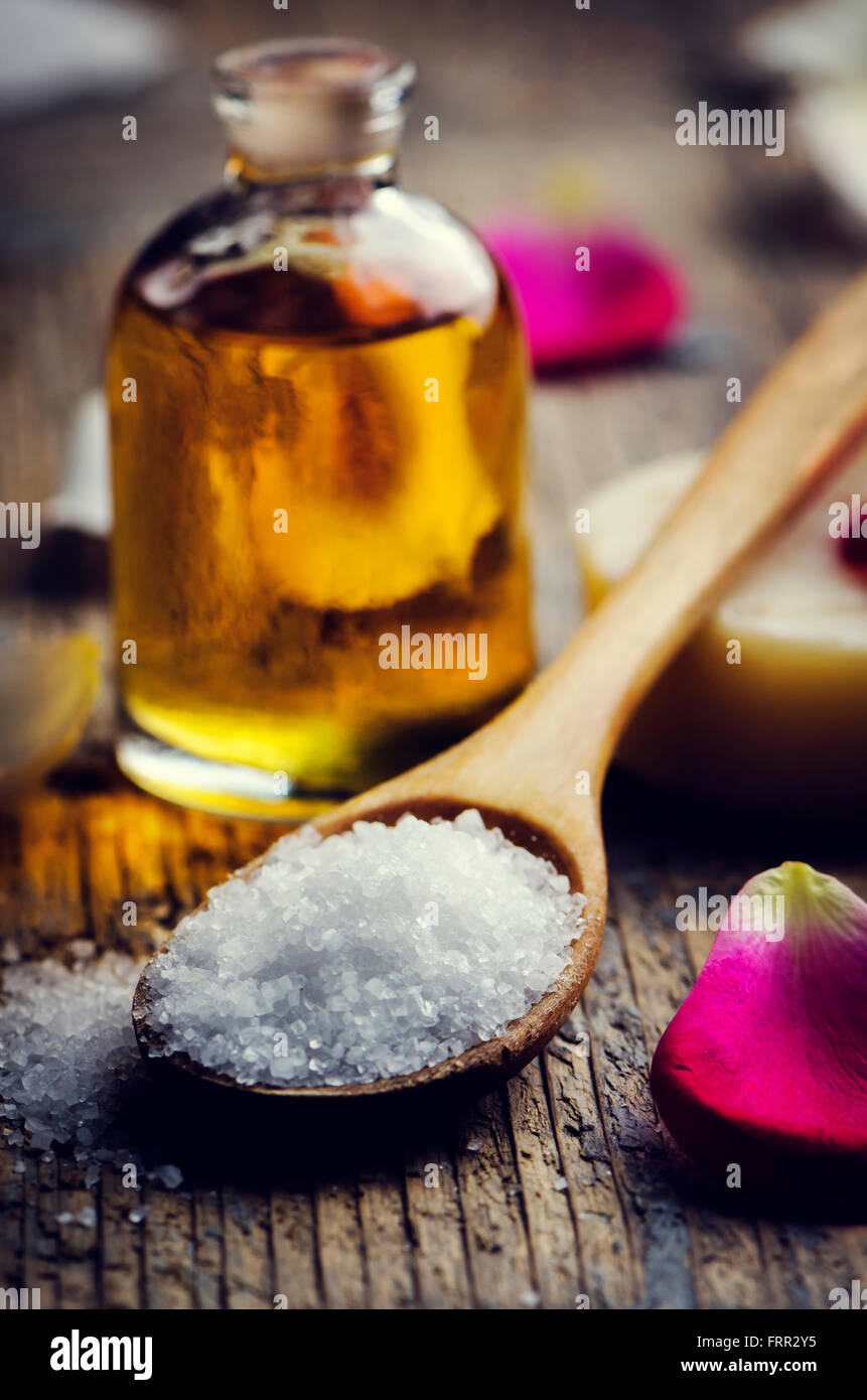 Sale marino in cucchiaio di legno e olio aromatico. Filtro retrò. Foto Stock