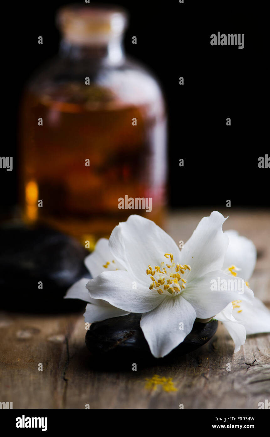 Concetto di Spa. Jasmin fiore e profumato olio su tavola di legno. Foto Stock