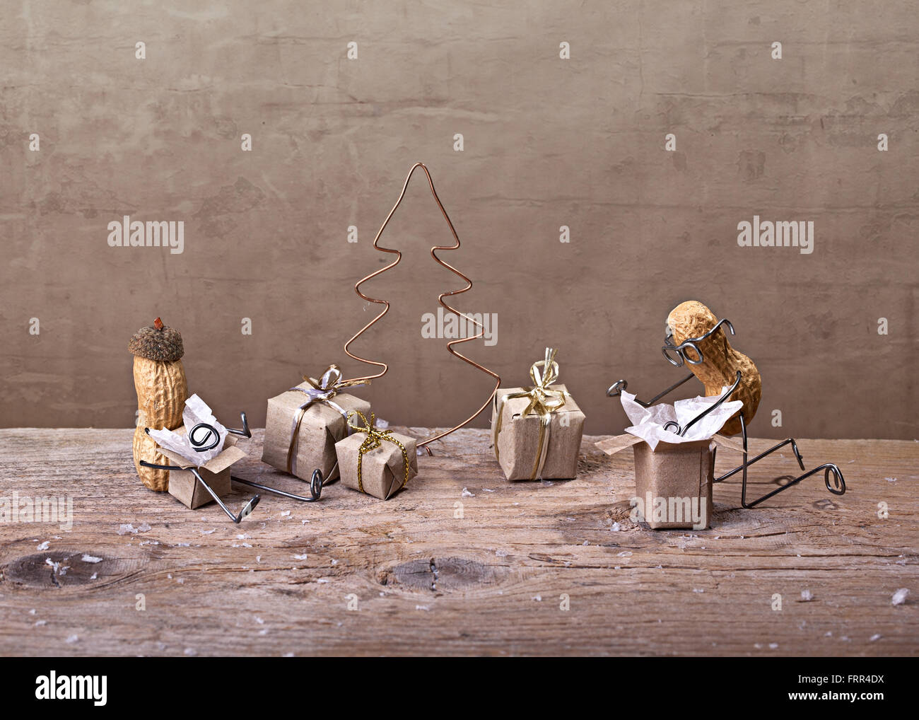 Cose semplici - miniaturizzato con persone di arachidi sul Natale disimballaggio la loro presenta Foto Stock