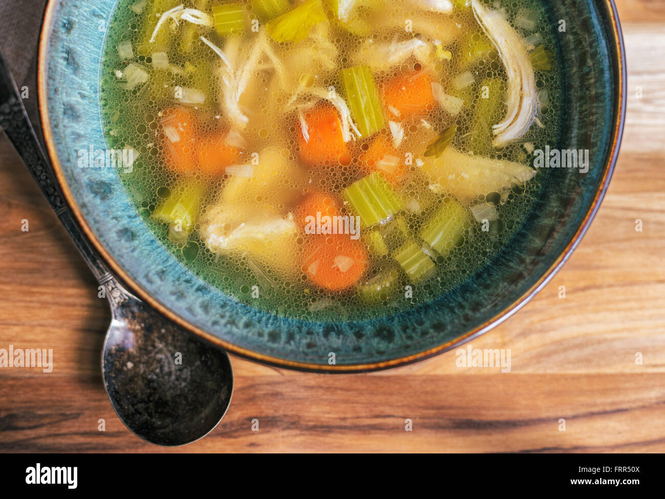 In casa la zuppa di pollo in una ciotola turchese con antichi cucchiaio. Foto Stock