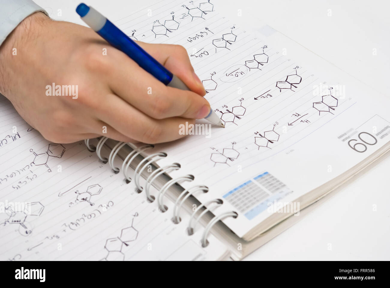 Il disegno dello studente formule strutturali in un notebook di chimica Foto Stock