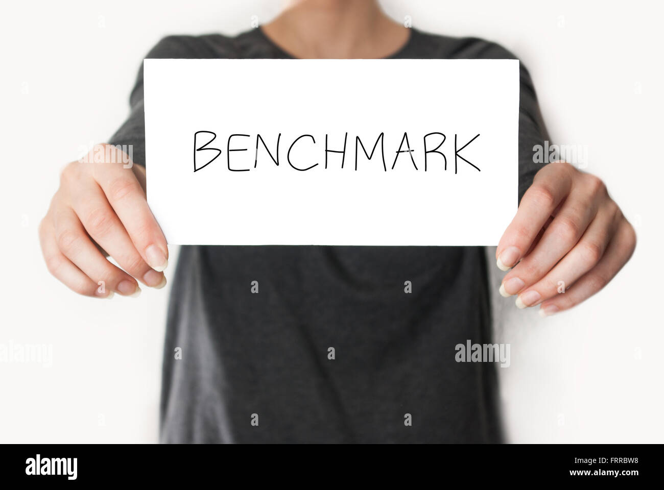 Benchmark. Femmina in camicia nera che mostra o titolari di una carta Foto Stock