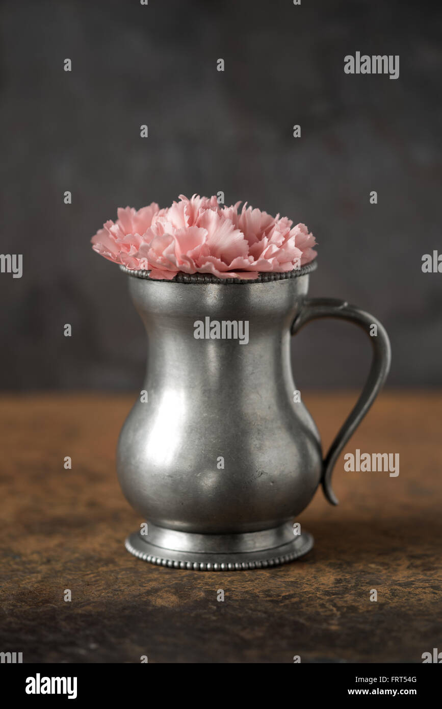 Carnation nel vaso di metallo sul tavolo di pietra in verticale Foto Stock