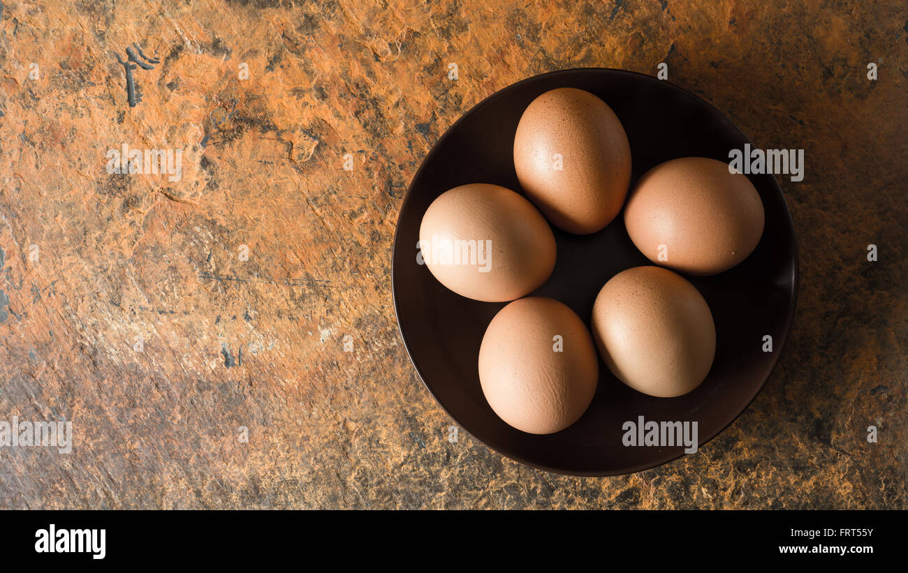 Le uova sulla piastra marrone vista superiore Foto Stock