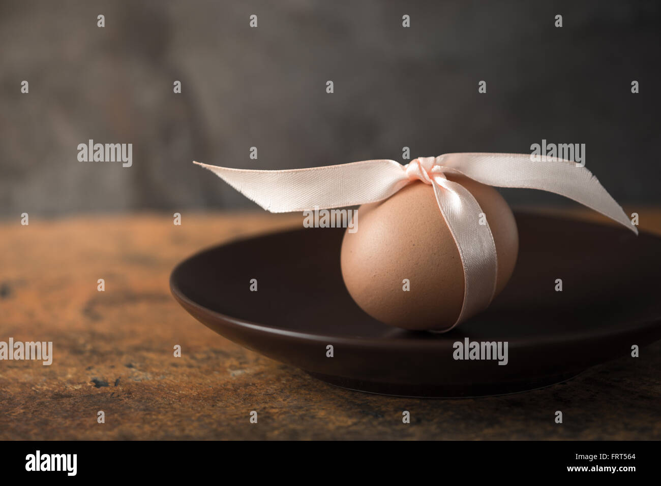Uovo con nastro sulla piastra marrone Foto Stock