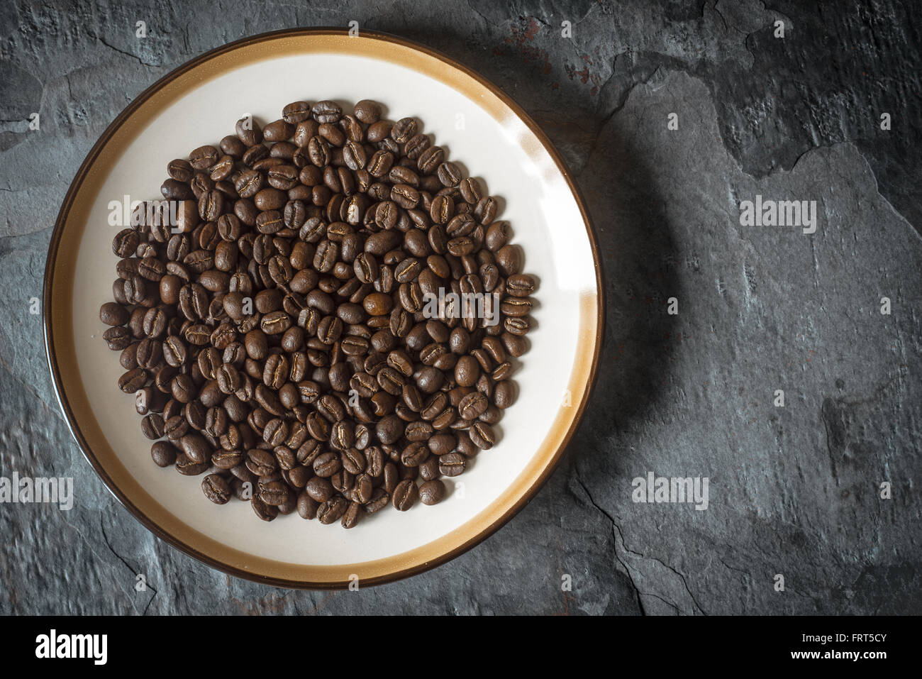 I chicchi di caffè sulla piastra del tavolo in pietra vista superiore Foto Stock