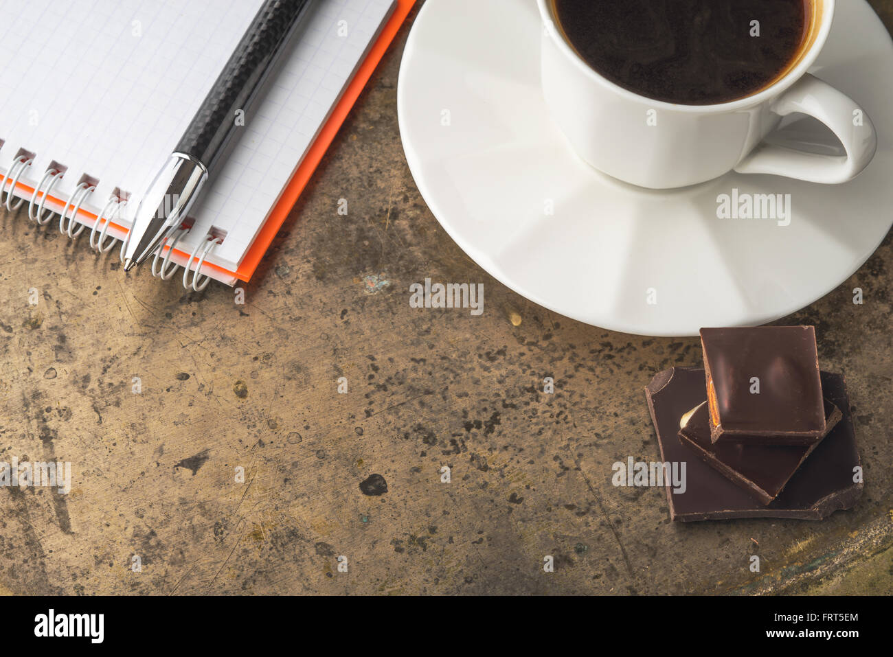 Tazza di caffè con cioccolato e notebook Foto Stock