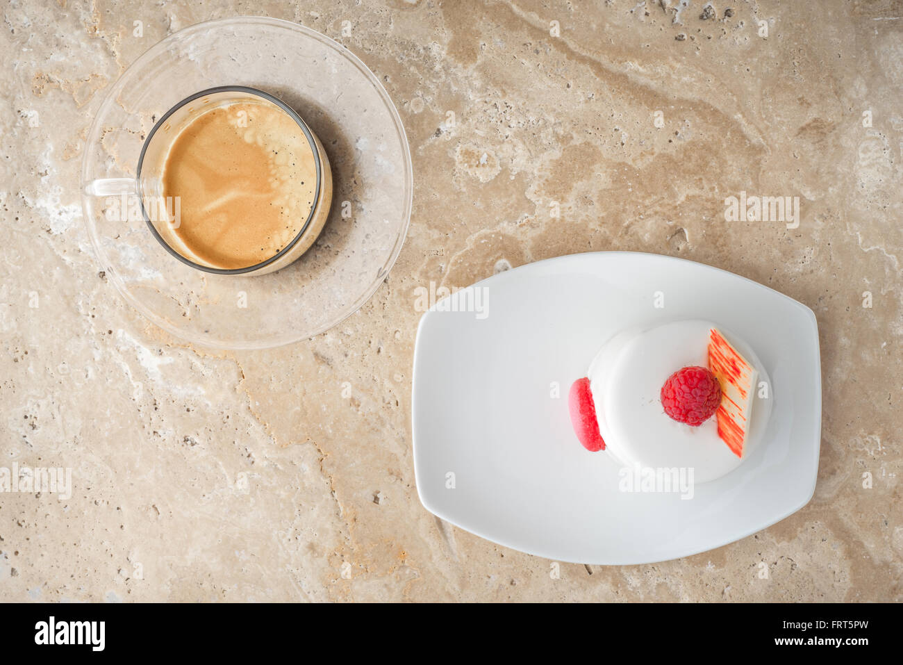 Torta bianca con lampone e caffè sul tavolo di pietra Foto Stock