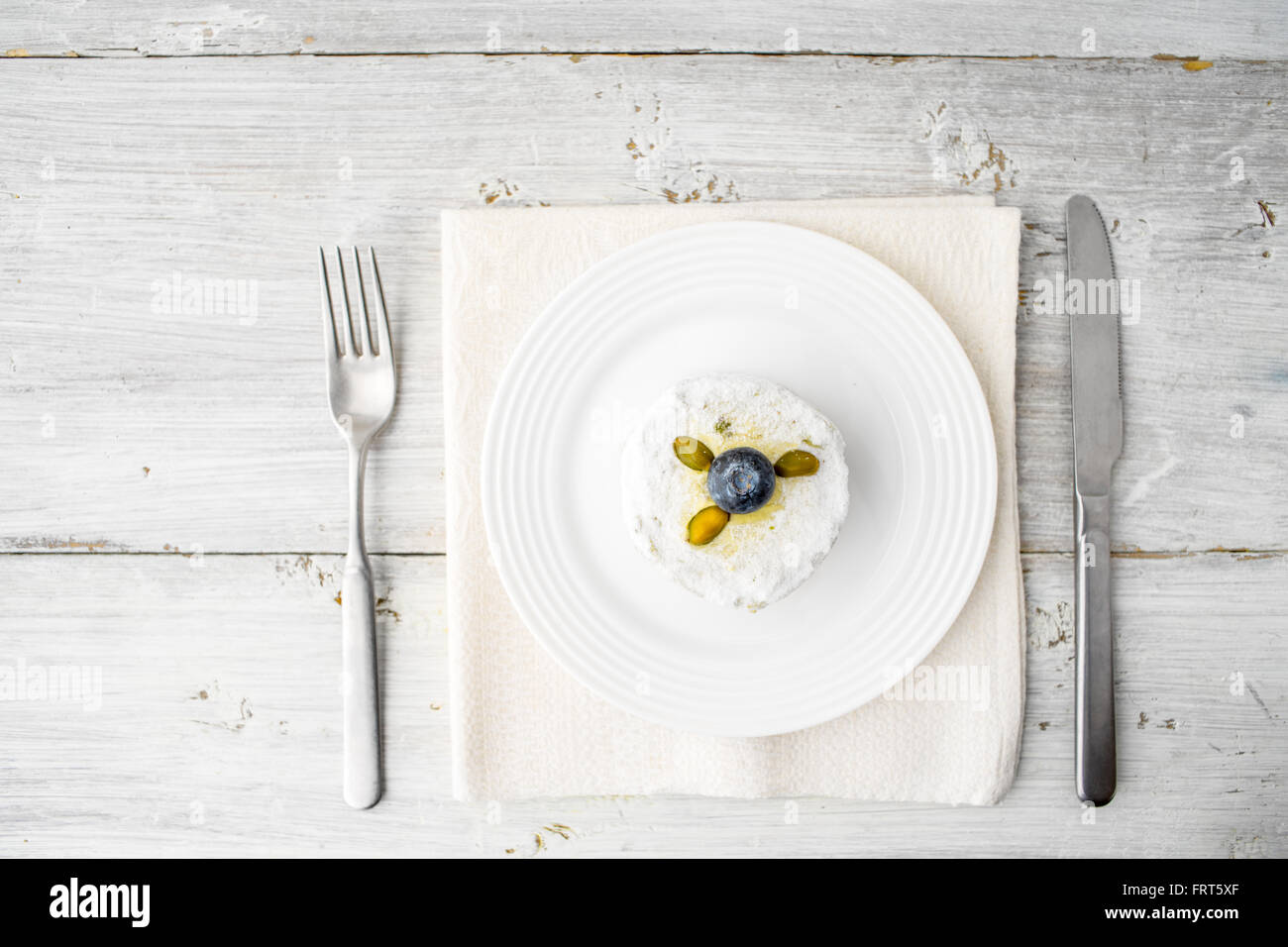 Torta con pistacchio e mirtillo sul bianco tavolo in legno vista superiore Foto Stock