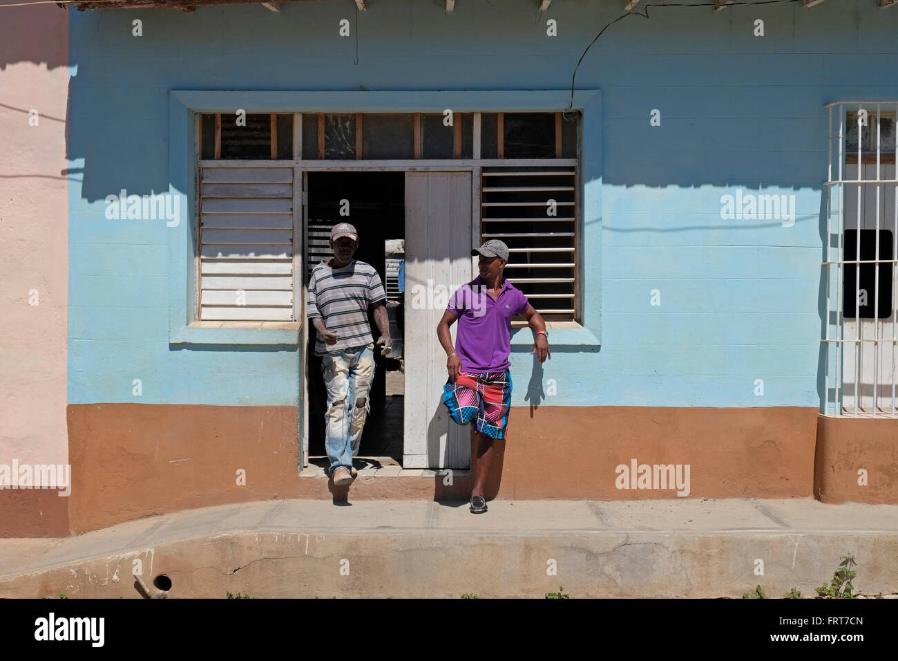 Afro-cubane uomini stavano in piedi al di fuori di una casa in Trinidad, Cuba. Foto Stock