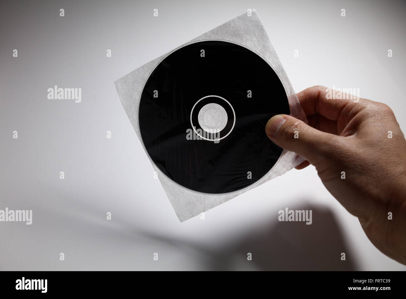 Mano che tiene un CD , DVD disco, concetto tecnologico. Foto Stock