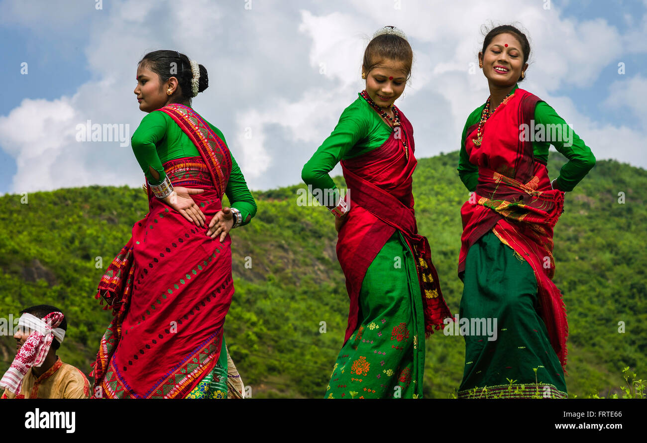Un gruppo di donne nei tradizionali sarees eseguire la danza Bihu all'aria aperta su un luminoso giorno d'estate. Foto Stock