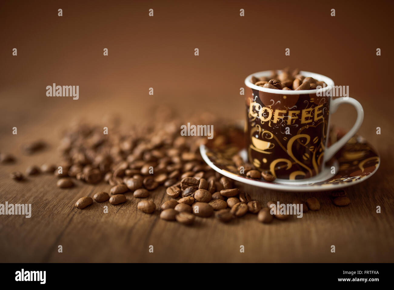Coppa piena di chicchi di caffè sullo sfondo di legno Foto Stock