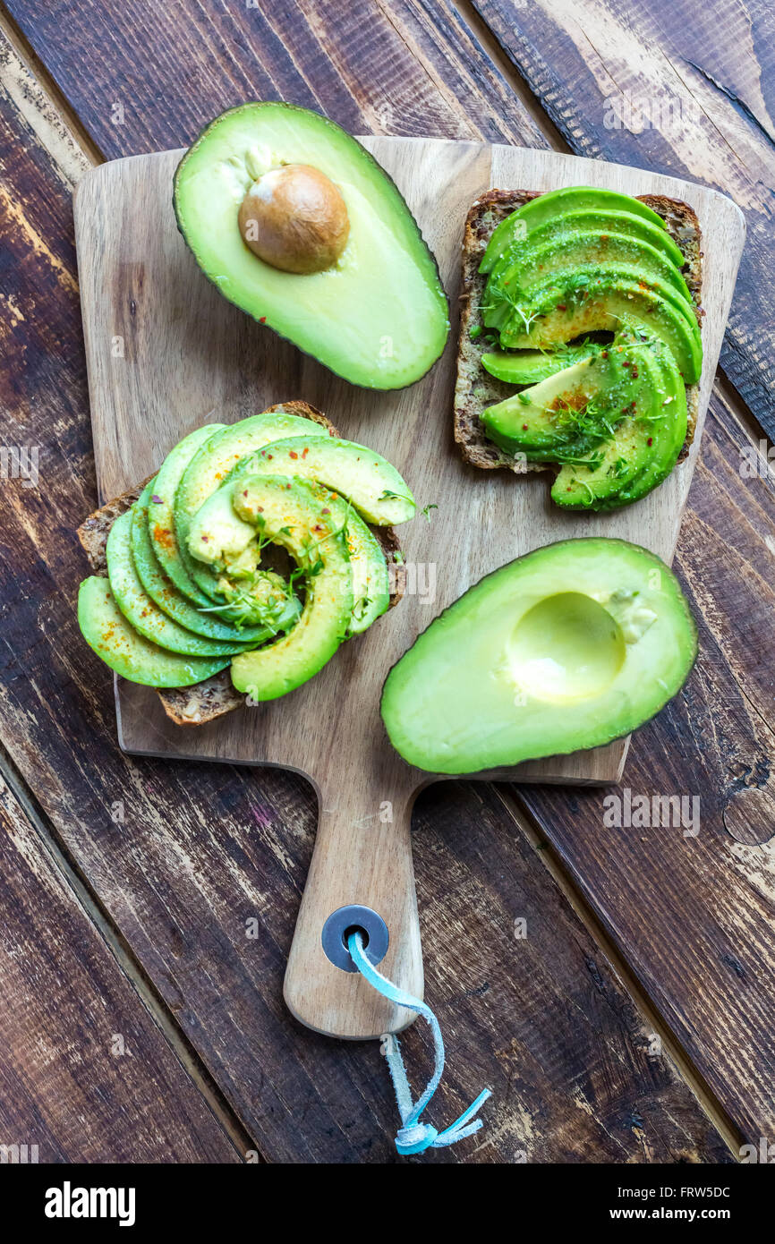 Pane di proteina guarnite con fette di avocado, il crescione e il peperoncino in polvere Foto Stock