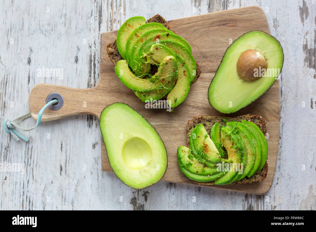 Pane di proteina guarnite con fette di avocado, il crescione e il peperoncino in polvere Foto Stock