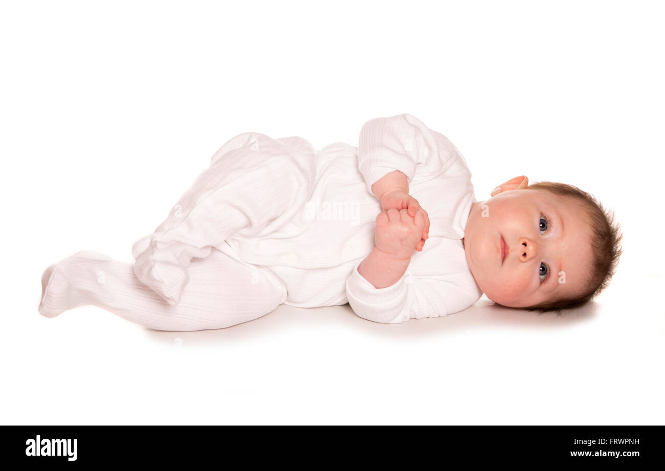 Baby imparare a rotolare sullo sfondo bianco Foto Stock