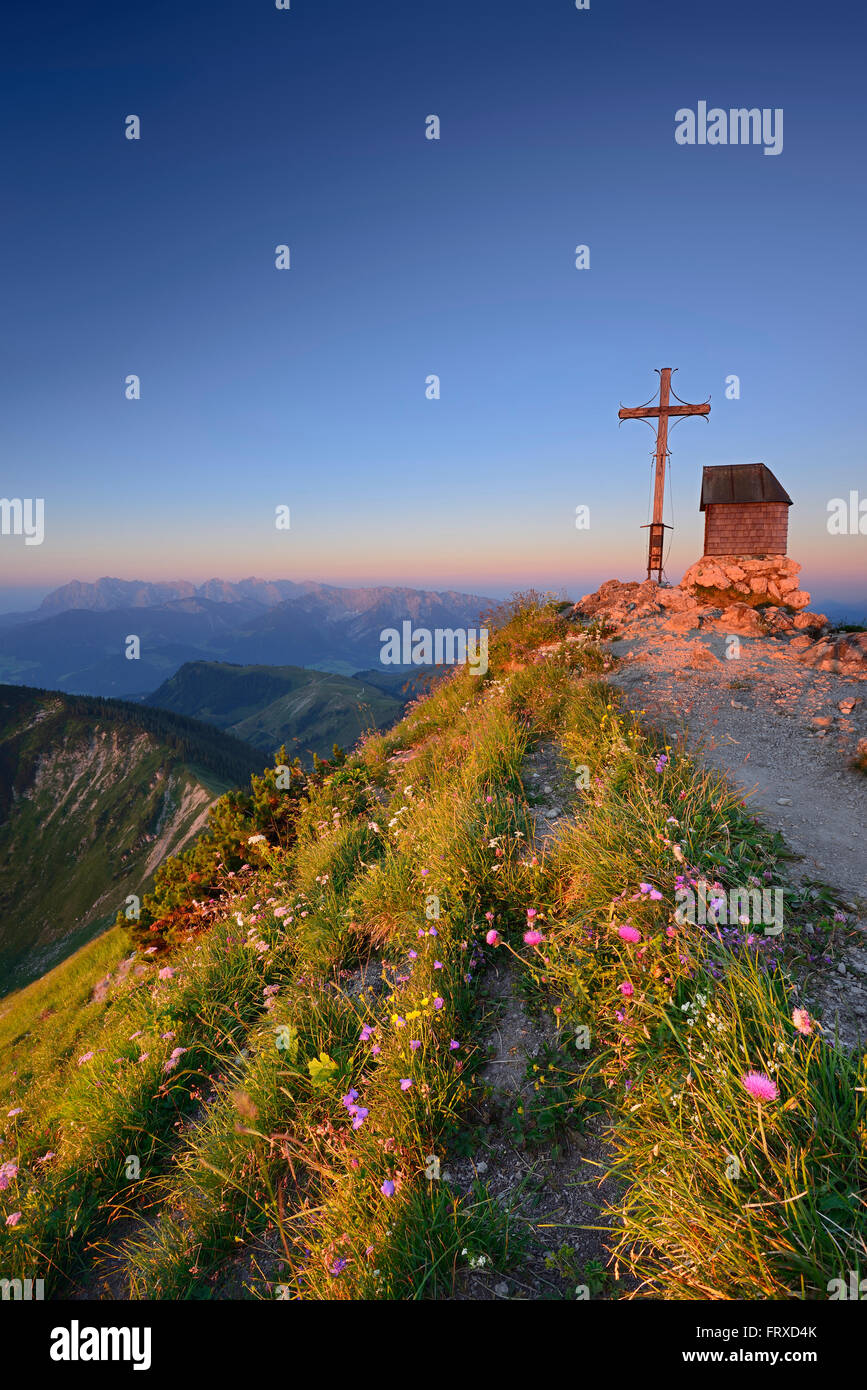 La cappella e la croce di vetta del monte Geigelstein, Kaiser gamma in background, Chiemgau Alpi, Chiemgau, Alta Baviera, Baviera, Germania Foto Stock