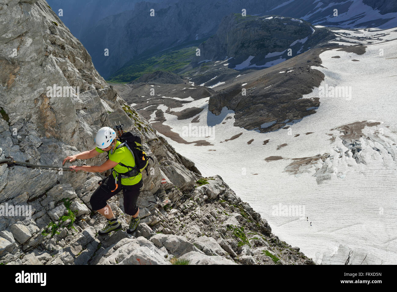 Donna ascendente sulla via ferrata di Zugspitze, ghiacciaio Hoellentalferner in background, Wetterstein mountain range, Alta Baviera, Baviera, Germania Foto Stock