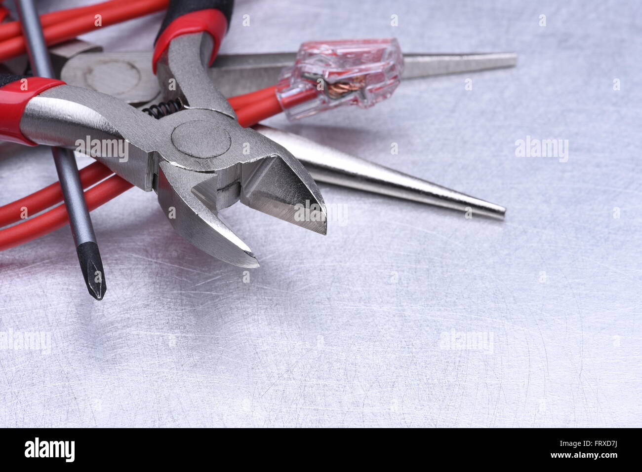 Strumenti per elettricista e i cavi grigio sulla superficie metallica Foto Stock