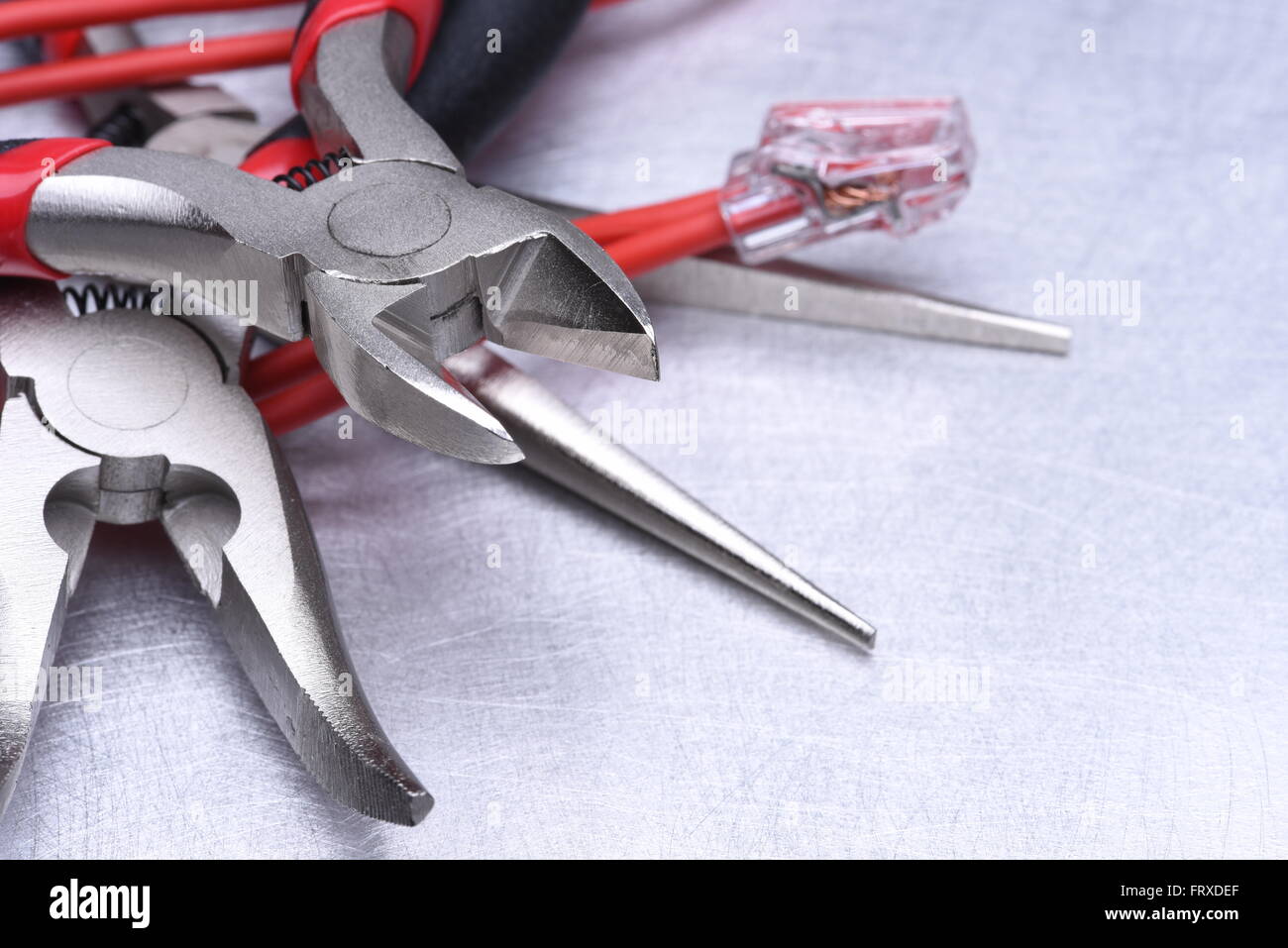 Strumenti per elettricista e i cavi grigio sulla superficie metallica Foto Stock