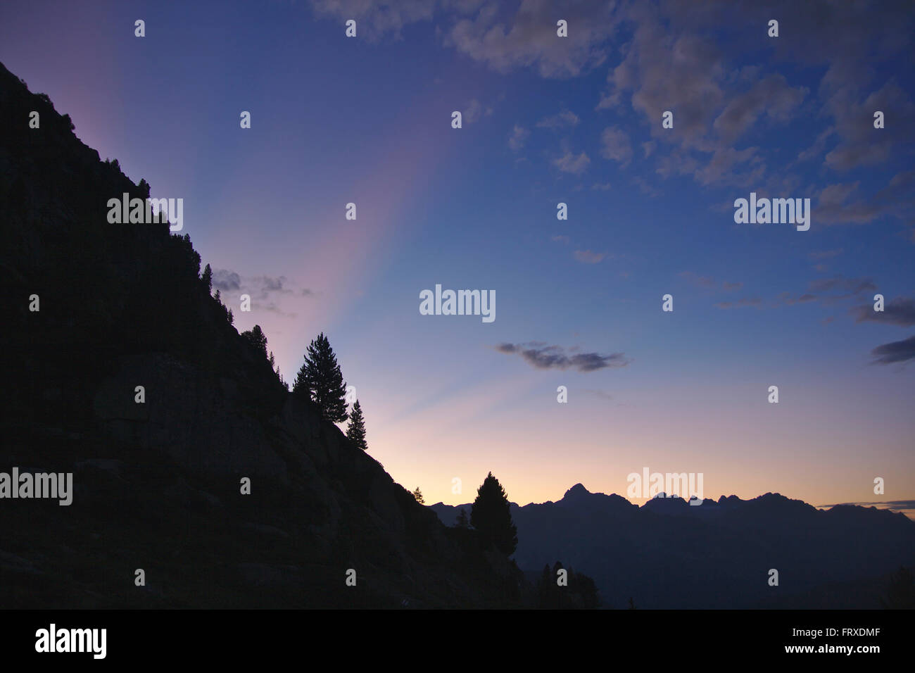 Luce rossa di travi e silhouette di montagne e alberi, tramonto, nei pressi de la Peutry, swiss parte del massiccio del Monte Bianco Foto Stock