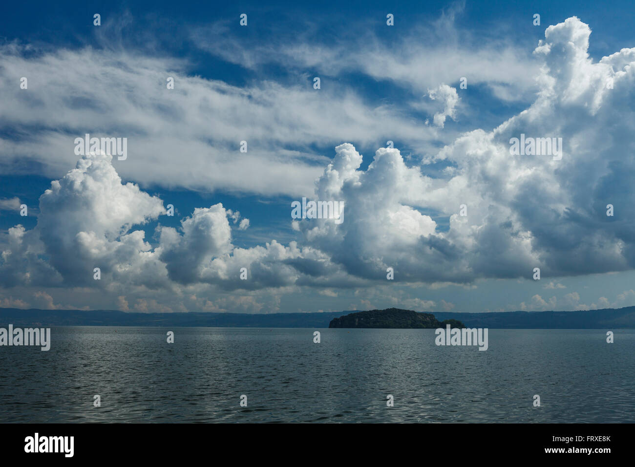 Cumulus nuvole sopra il lago di Lago di Bolsena, Isola Martana im Hintergrund, il cratere del lago di origine vulcanica, vicino a Montefiascone, provincia di Viterbo, Lazio, l'Italia, Europa Foto Stock