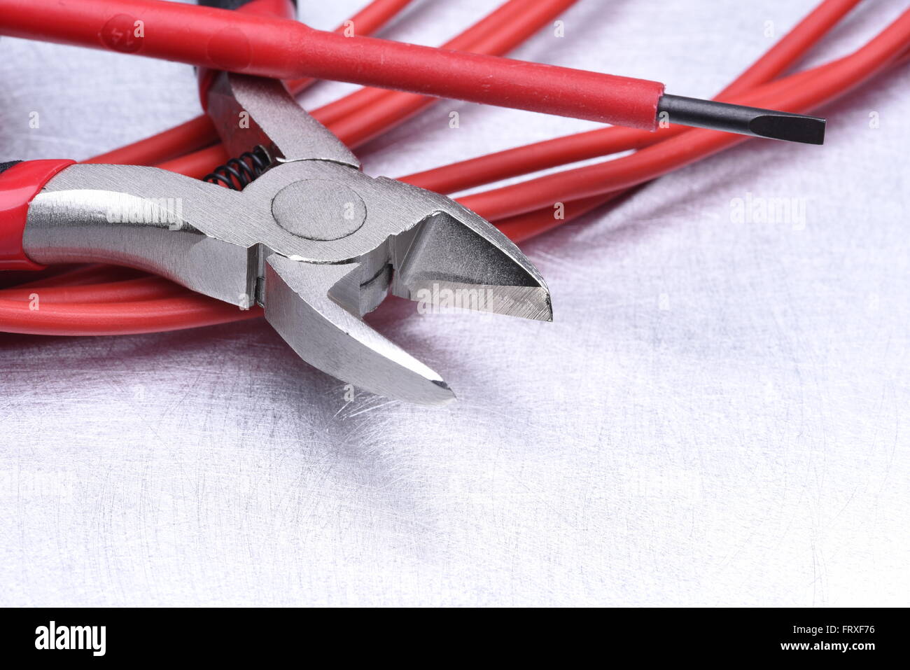 Strumenti per elettricista e i cavi grigio sulla superficie metallica Foto Stock